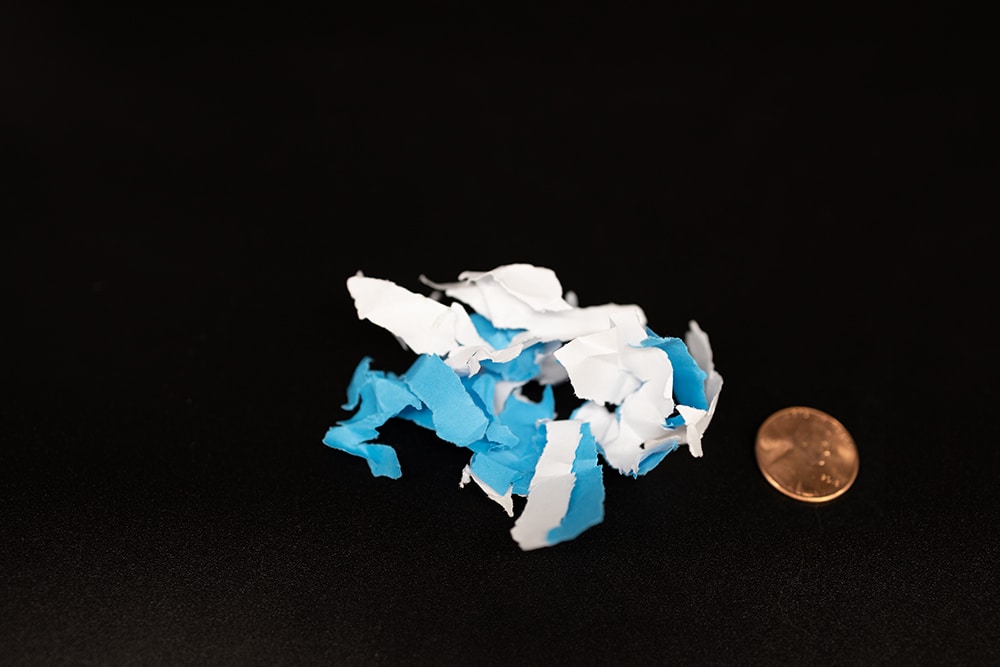 DIN Level P-2 Paper Shred with penny for size comparison