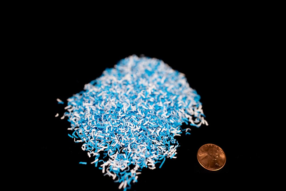 DIN Level P-7 Paper Shred with penny for size comparison